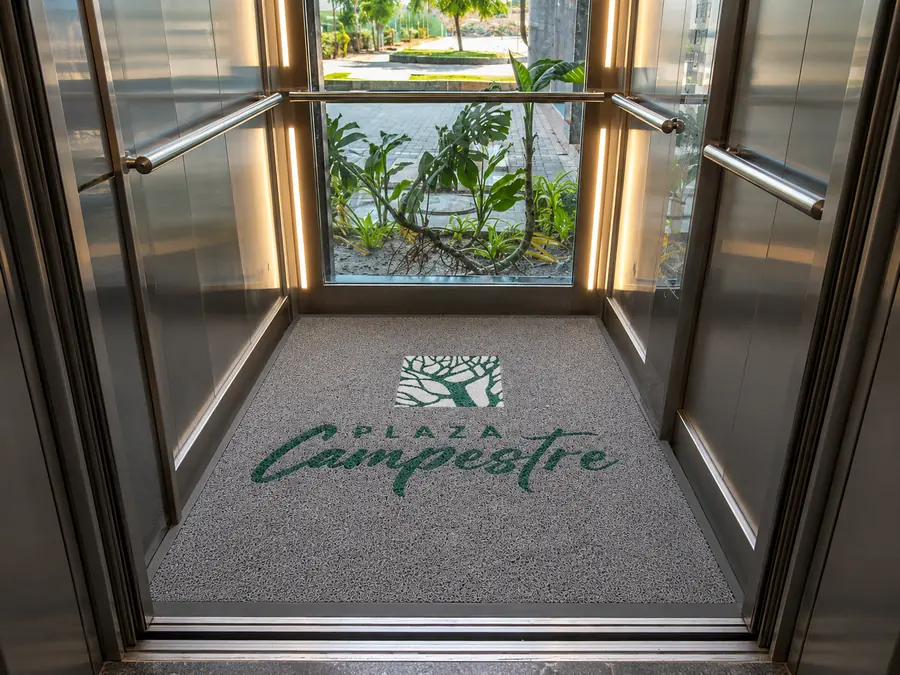 Tapete personalizado con logo del centro comercial Plaza Campestre en la entrada de un ascensor